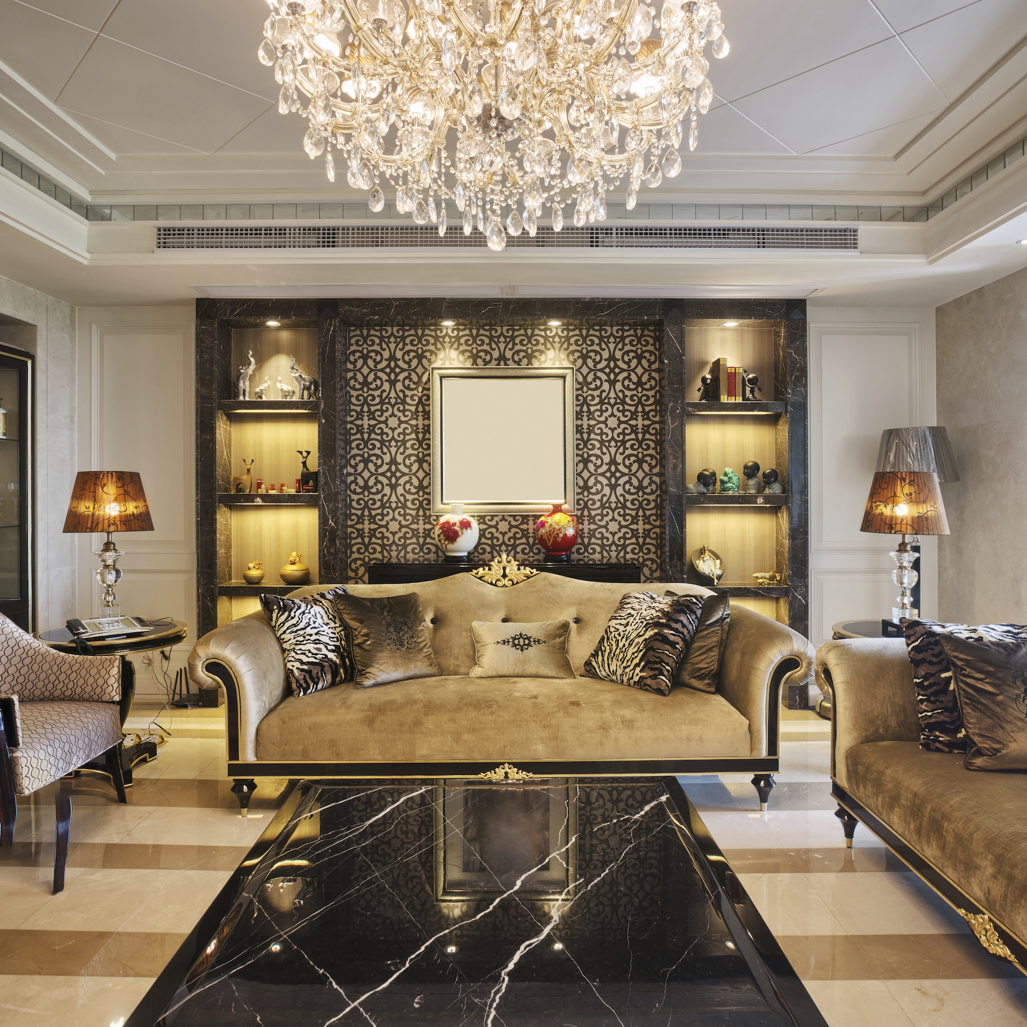 A luxury home sitting room with chandelier, brocade sofa and marble floors.